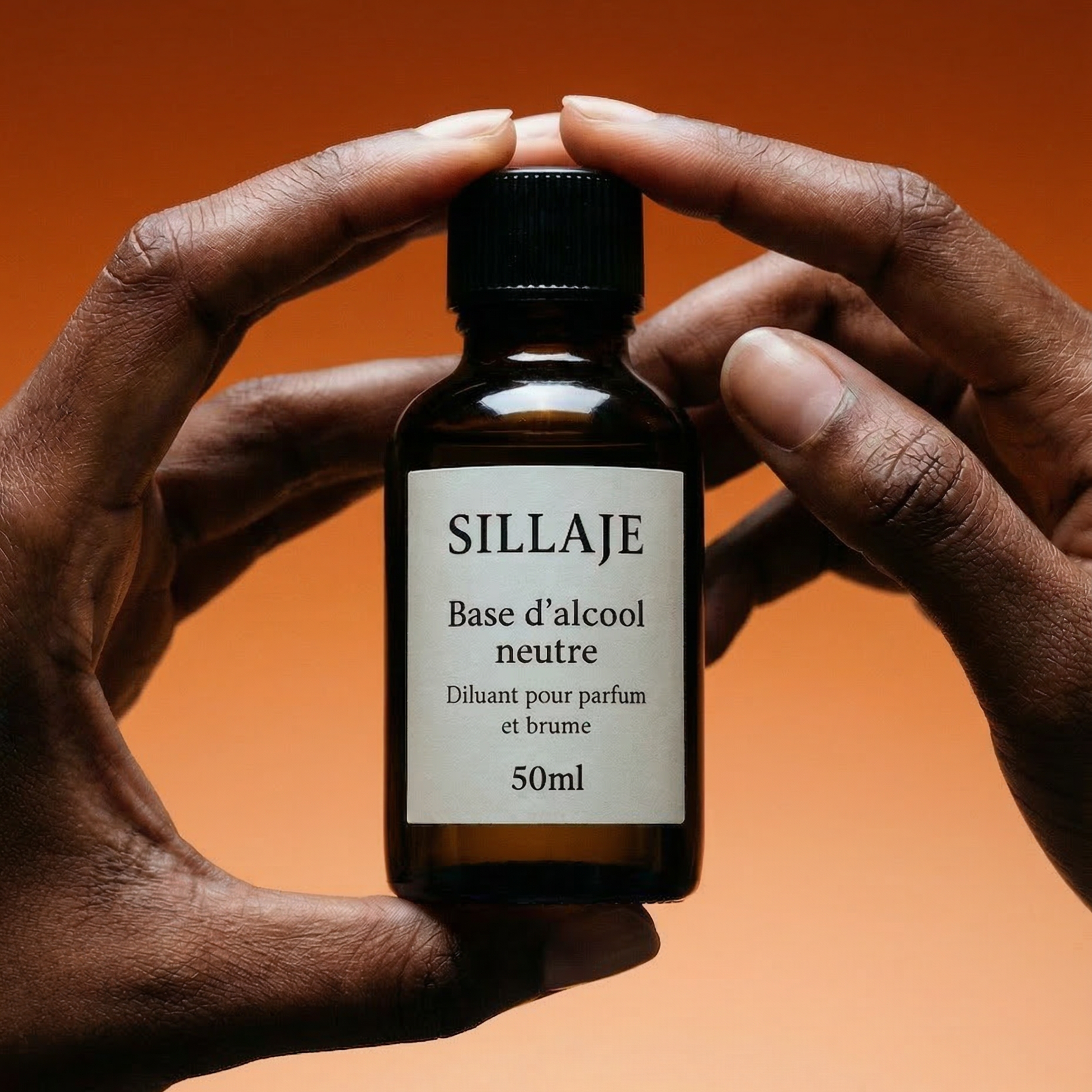 Flacon d'alcool 50ml pour création de parfum tenu en main